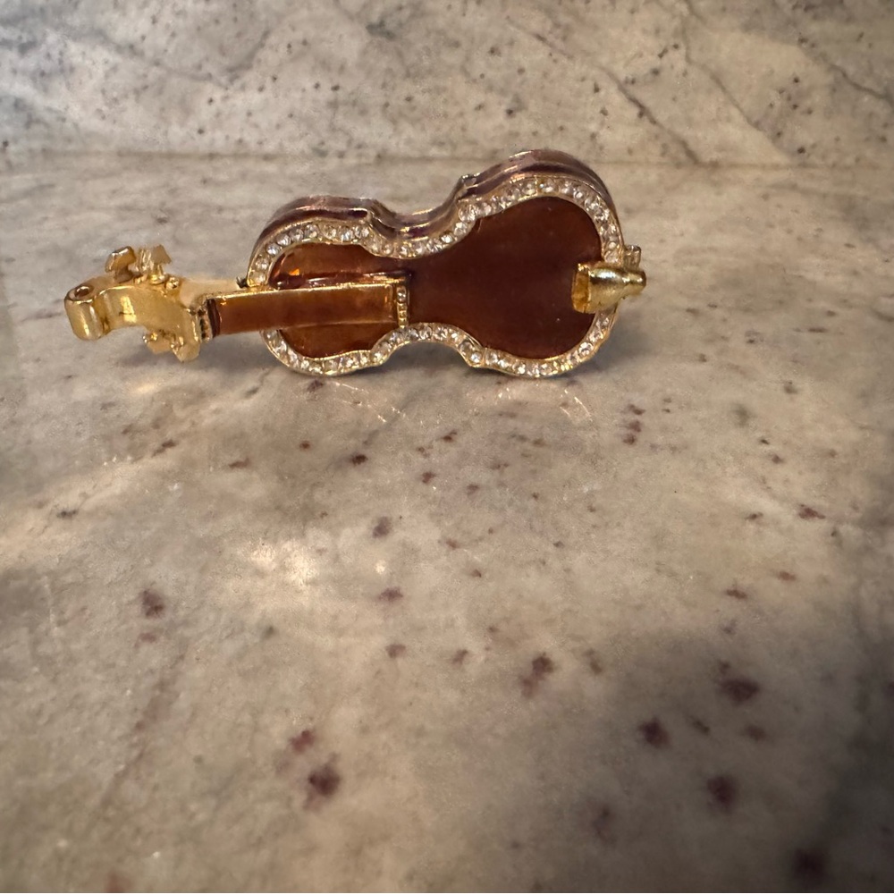 a bronze violin with gold trimming and clear crystals trinket